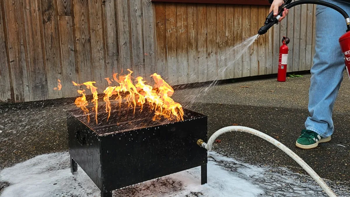 Stagiaire manipulant un extincteur sur un bac à feu